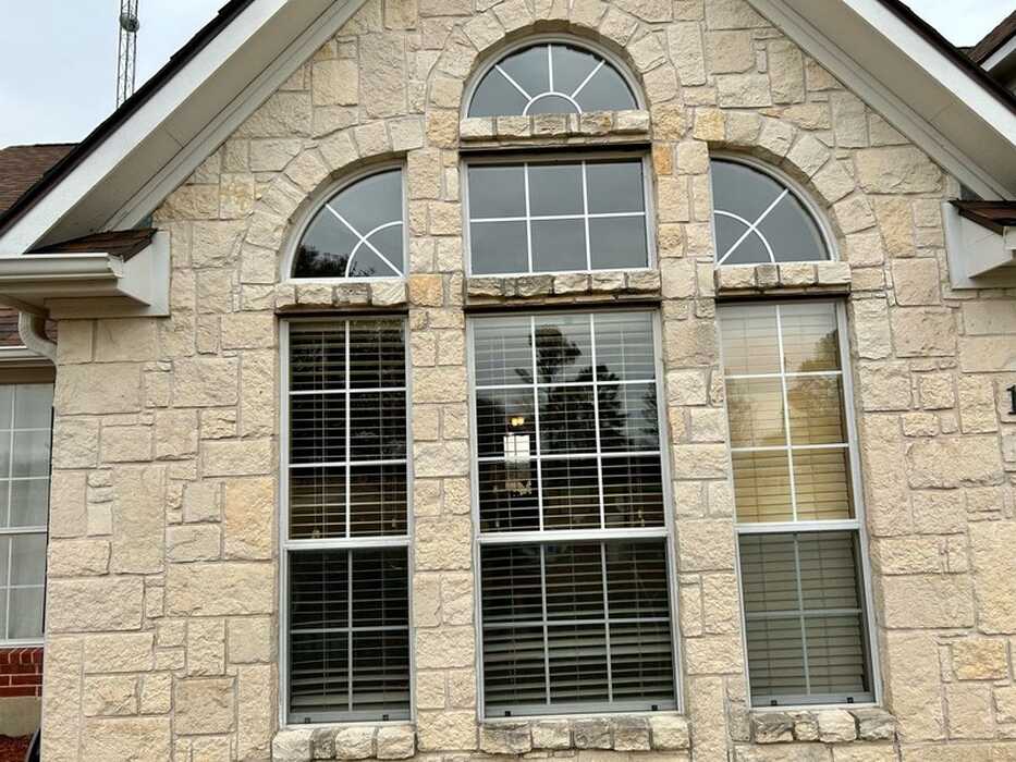 Arched window replacement on a stone home in Sherman, TX